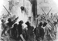 Angry mob watches as the body of a lynched African American man burns